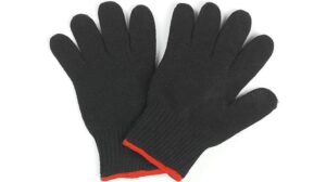 Ein Paar schwarze Kochhandschuhe aus Strick mit rotem Besatz an den Handgelenken, flach auf weißem Untergrund liegend – perfekt für Ihren nächsten GOURMETmaxx 03251 Küchentest.