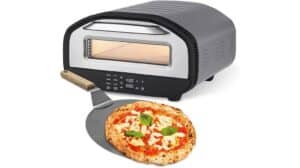 Ein GOURMETmaxx Elektrischer Pizza-Ofen mit digitaler Anzeige ist abgebildet. Im Testbericht sieht man einen Pizzaschieber mit einer frisch gebackenen Pizza, belegt mit Käse, Tomaten und Basilikum.