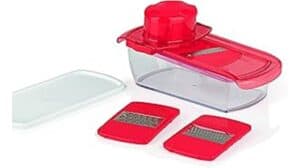 Der Gourmetmaxx Chopper Obst-Gemüse-Schneider aus rot-durchsichtigem Kunststoff mit Lebensmittelhalter, zwei auswechselbaren Reibeklingen und weißem Deckel auf weißem Hintergrund – ideal für jede Küche mit Top-Bewertung.