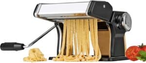 Die GOURMETmaxx 09952 Nudelmaschine mit Handkurbel produziert frische Pasta-Nudeln, während Tomaten und Nudelteig neben der Maschine Platz finden – perfekt für einen hausgemachten Gourmet-Touch. Entdecken Sie Top-Bewertungen von Pasta-Enthusiasten!.