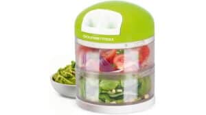 Ein grüner, transparenter Gemüseschneider mit der Aufschrift „GOURMETmaxx“ ist mit frischem Gemüse gefüllt und daneben steht eine kleine Schüssel Guacamole – perfekt für schnelle Gerichte mit Top-Bewertung!.