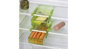 Grüne Schubladen aus Kunststoff helfen beim Organisieren der Küche im Kühlschrank und bieten Platz für Karotten, Käse und Gewürze. Auch ein Glas Essiggurken, Wurst und sogar eine GOURMETmaxx-Klemme sind auf den Regalen zu sehen.
