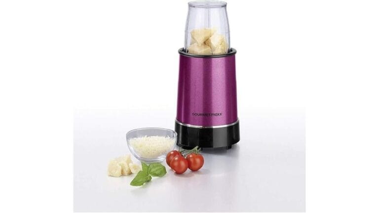 Ein lilafarbener GOURMETmaxx-Standmixer mit gehackten Zutaten darin, daneben eine Glasschüssel mit geriebenem Käse, Kirschtomaten und frischen Basilikumblättern – perfekt für jeden Smoothie-Maker-Enthusiasten.
